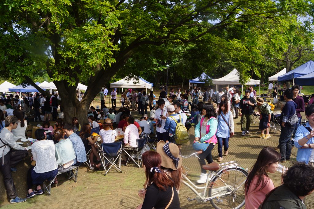 大勢の人が公園でお花見をする様子