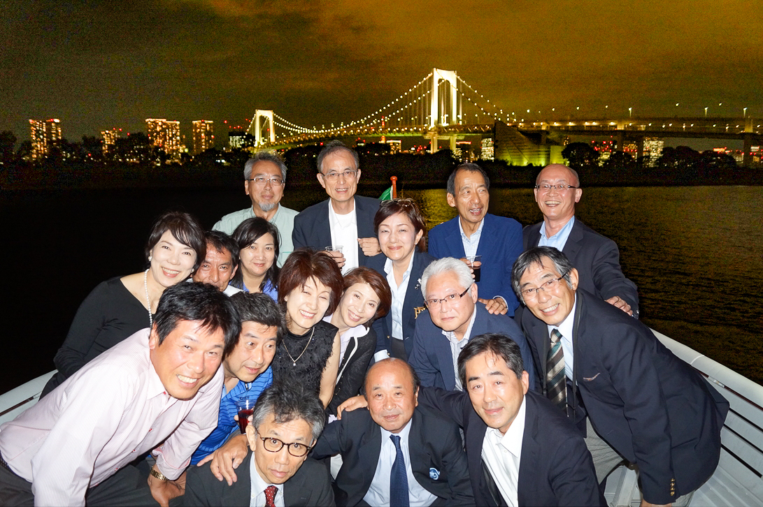 東京湾の夜景をバックに集合写真を撮影