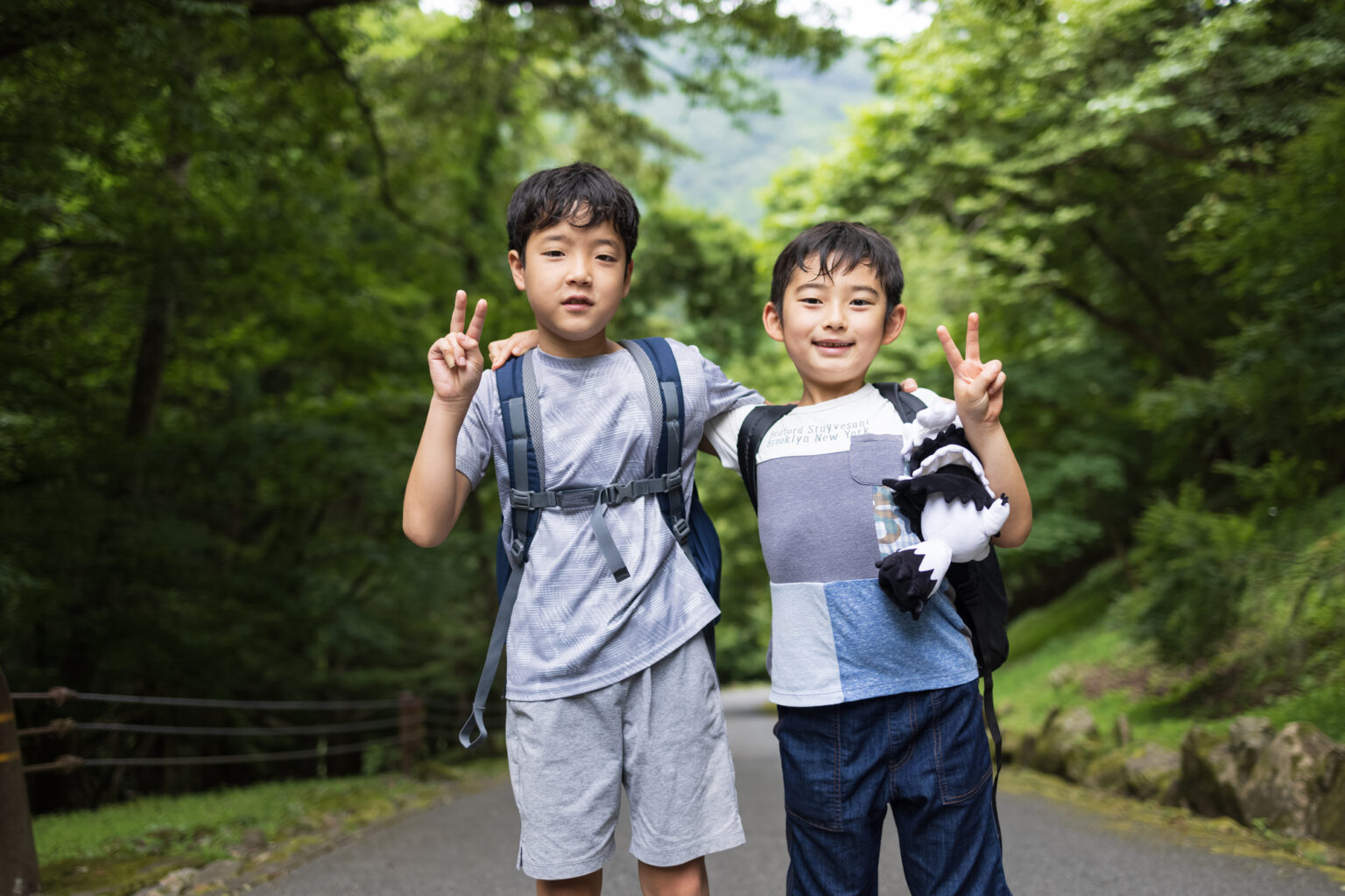 ピースする小学生の男の子2人組