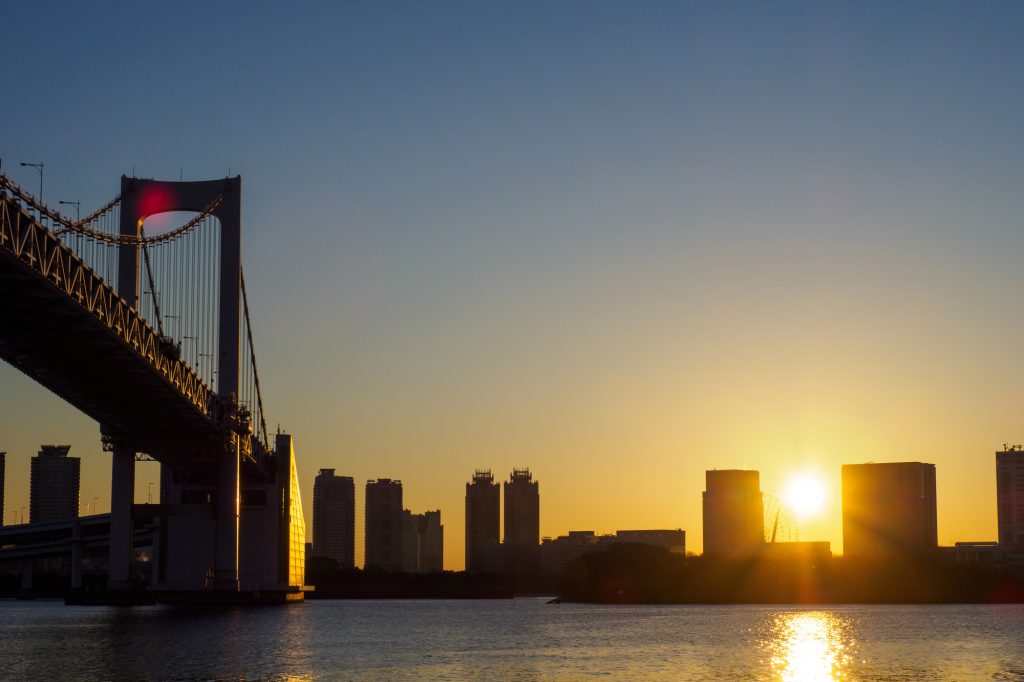 明け方の空に輝く太陽が昇ろうとしている