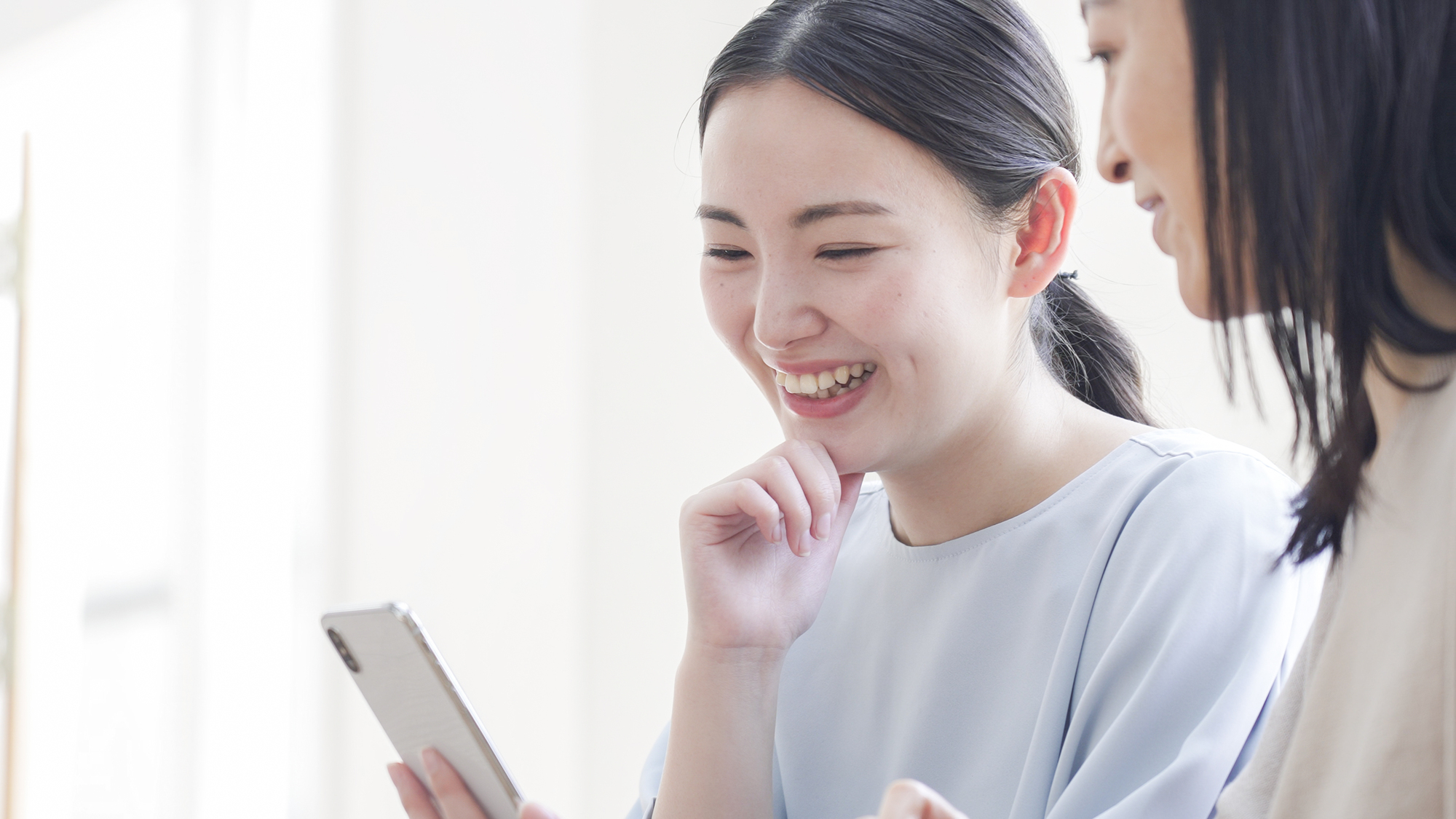 女性がスマホを見てほほ笑む